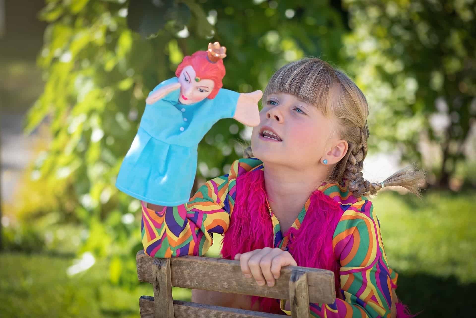 girl telling story with puppet summer activities